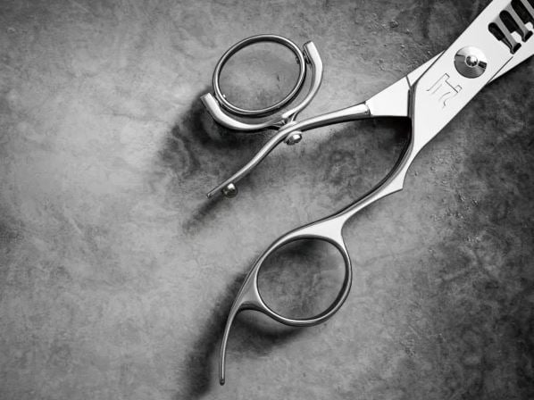 Hattori Hanzo swivel thumb shears showing the rotating pivot mechanism that allows the thumb ring to move freely, reducing wrist strain for barbers and stylists